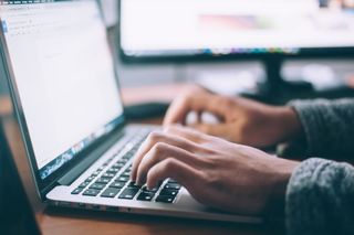 Person typing on a laptop in a quiet study setting